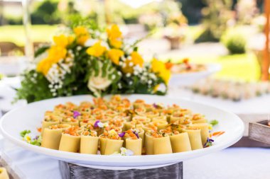 Çeşitli mezeler ve makarna ile parmak yiyecekler.