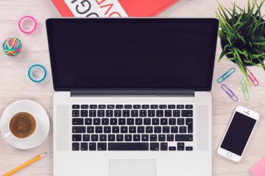 Ofis ahşap masada açık macbook dizüstü bilgisayar ve iphone smartphone ile üst görünüm düz yatıyordu çalışma alanı mockup