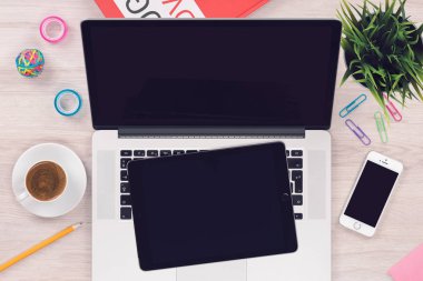 Üst görünüm düz açık macbook dizüstü bilgisayar, ipad tablet pc ve ofis ahşap masada iphone smartphone ile çalışma alanı mockup yatıyordu