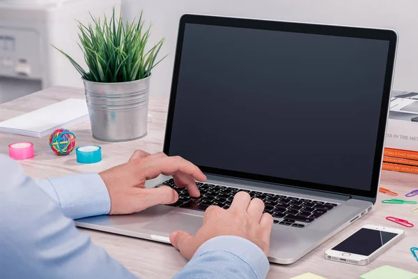 Mans hands keyboarding on macbook laptop with blank screen mockup — Stock Photo, Image