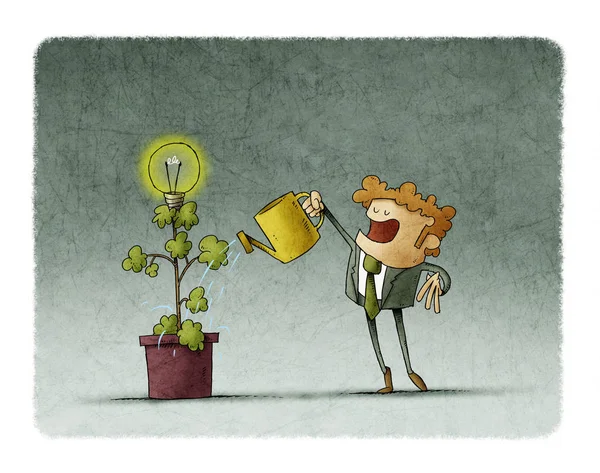 Businessman is watering a plant from which a light bulb blooms. — Stock Photo, Image