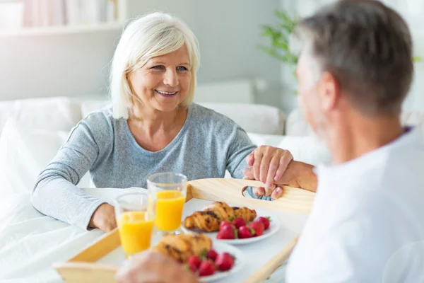 Senior koppel genieten van ontbijt op bed — Stockfoto