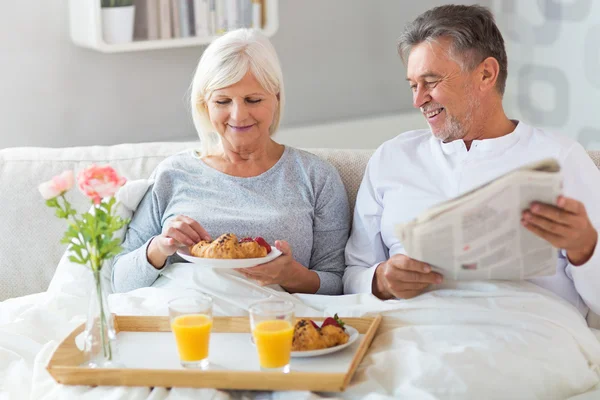 Senior koppel genieten van ontbijt op bed — Stockfoto