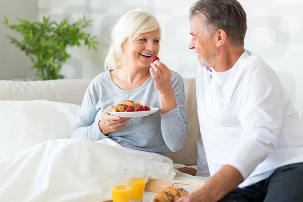 Senior koppel genieten van ontbijt op bed — Stockfoto