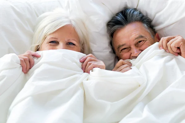 Idősebb pár együtt fekszenek az ágyban. — Stock Fotó