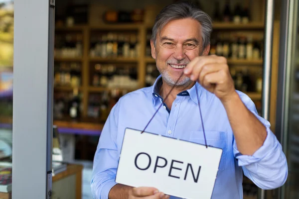 Wine shop owner holding open sign — Φωτογραφία Αρχείου