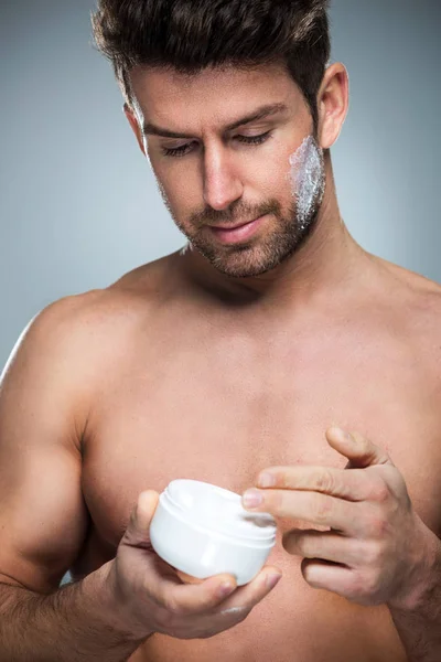 Muž použitím krém na obličej — Stock fotografie