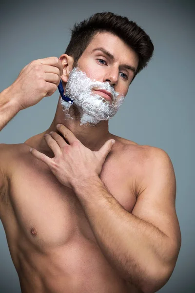Красивый мужчина бреется — стоковое фото