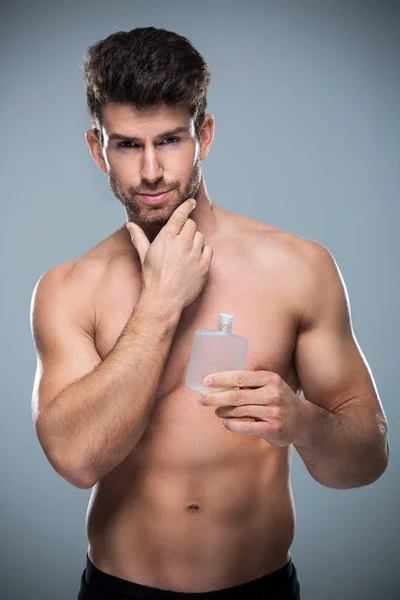 Mężczyzna trzymający butelkę perfum — Zdjęcie stockowe