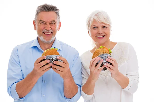 Casal de idosos comendo hambúrgueres Imagens De Bancos De Imagens
