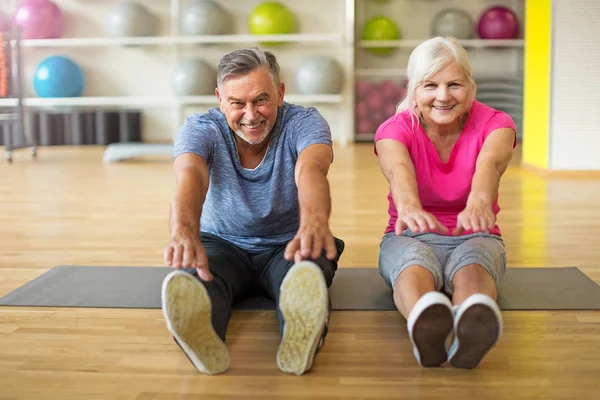 Senior pareja haciendo ejercicio en el gimnasio — Foto de Stock