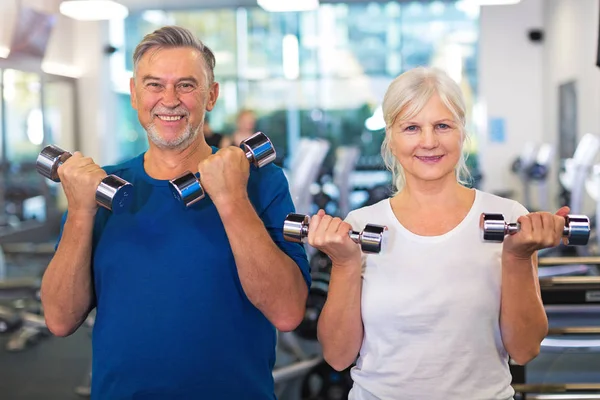 Senior couple exercising in gym — Stock Photo, Image