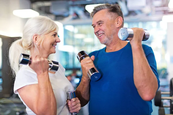 Senior pareja haciendo ejercicio en el gimnasio — Foto de Stock
