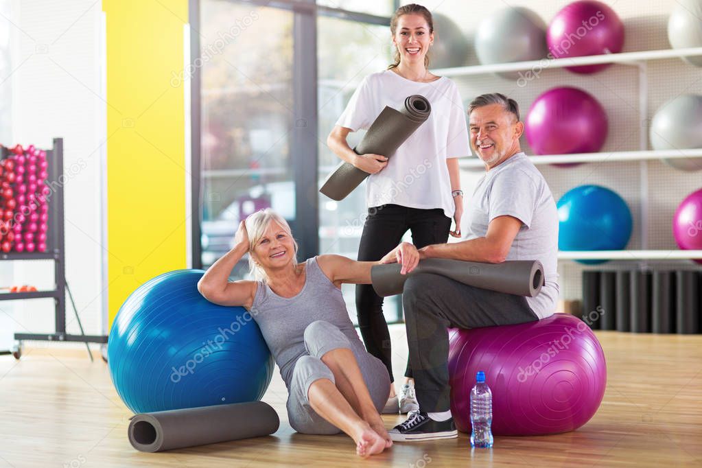 Senior couple training in the gym with a personal trainer