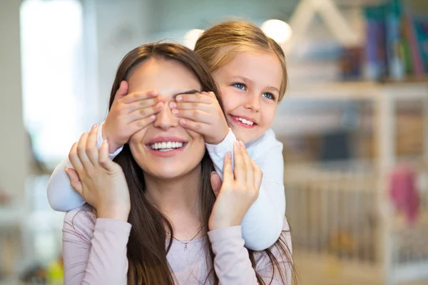 Ευτυχισμένη κοριτσάκι καλύπτει τα μάτια της μητέρας — Φωτογραφία Αρχείου