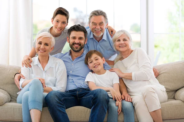 Famiglia sorridente sul divano — Foto Stock