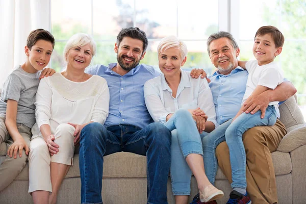 Kanepe üzerinde gülümseyen aile — Stok fotoğraf