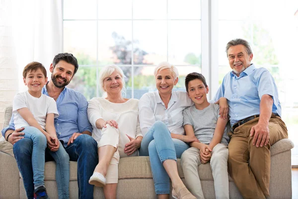 Familia sonriente en el sofá — Foto de Stock