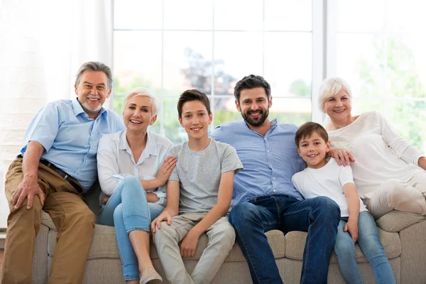 Família sorridente no sofá — Fotografia de Stock