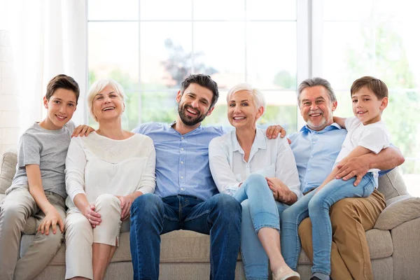 Família sorridente no sofá — Fotografia de Stock