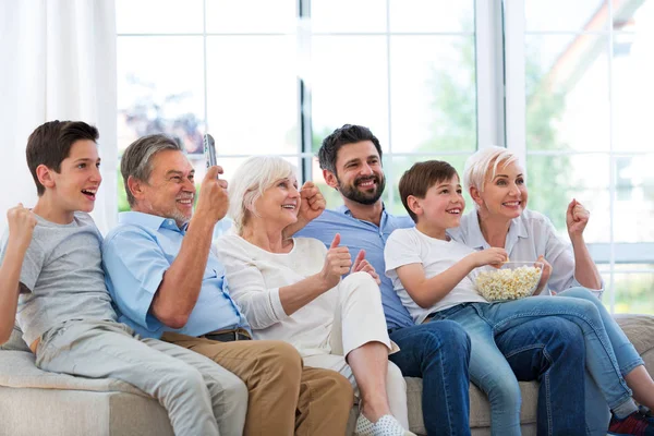 Família assistindo tv no sofá — Fotografia de Stock