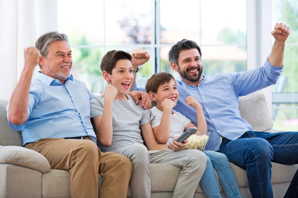 Familia de tres generaciones viendo la televisión — Foto de Stock