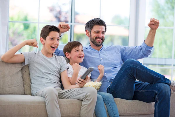 Pai e filhos assistindo tv em casa — Fotografia de Stock
