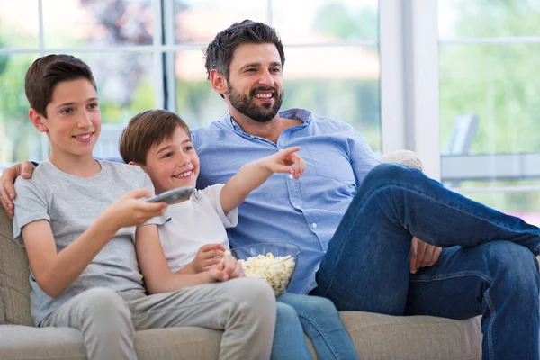 Отец и сыновья смотрят телевизор дома — стоковое фото