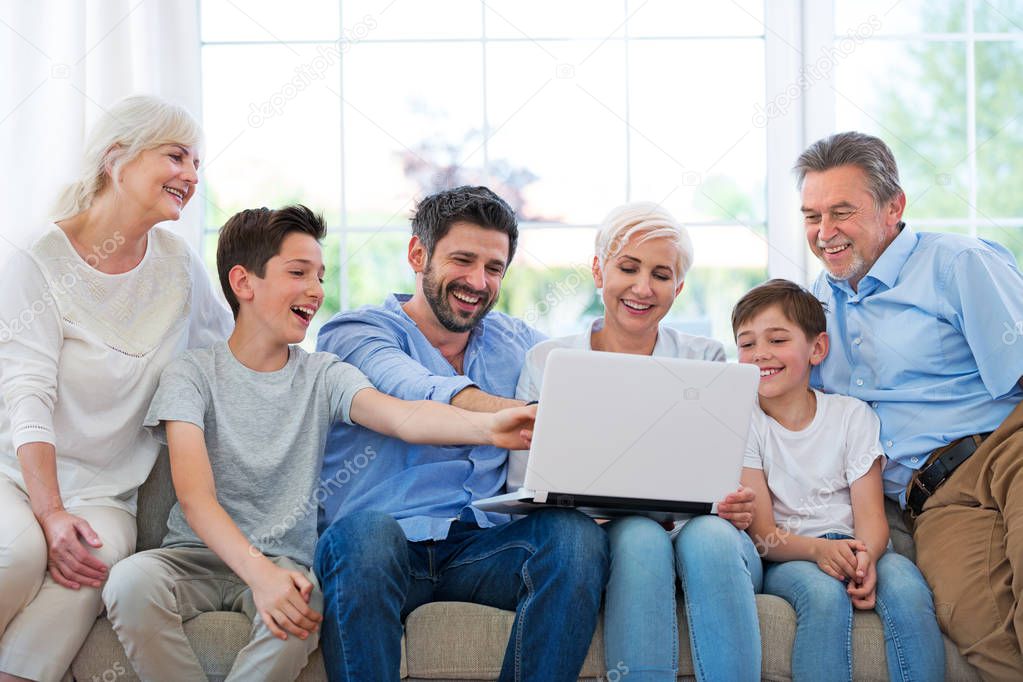 Family using laptop on a sofa
