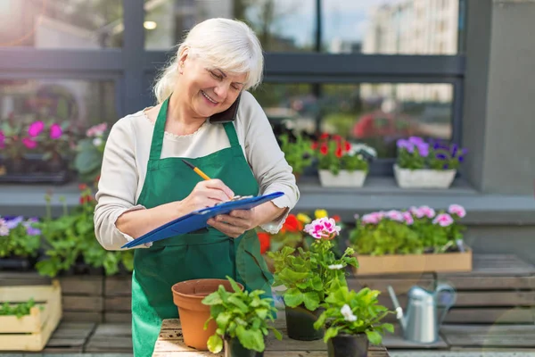 Mujer trabajando en floristería — Foto de Stock