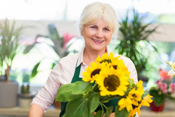 Vrouw die werkt in de winkel van de bloemist — Stockfoto