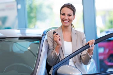 Yeni arabası ile mutlu bir genç kadın