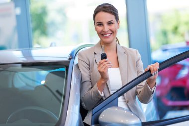 Yeni arabası ile mutlu bir genç kadın