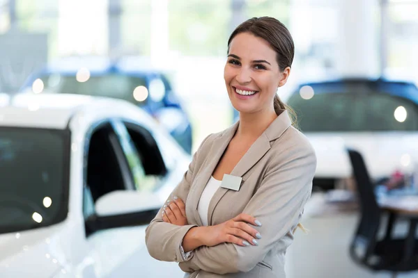 Femeie dealer auto în picioare în showroom — Fotografie, imagine de stoc