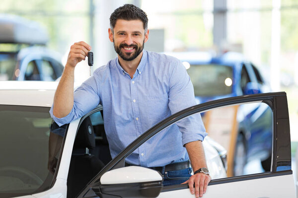 Счастливый молодой человек со своей новой машиной
