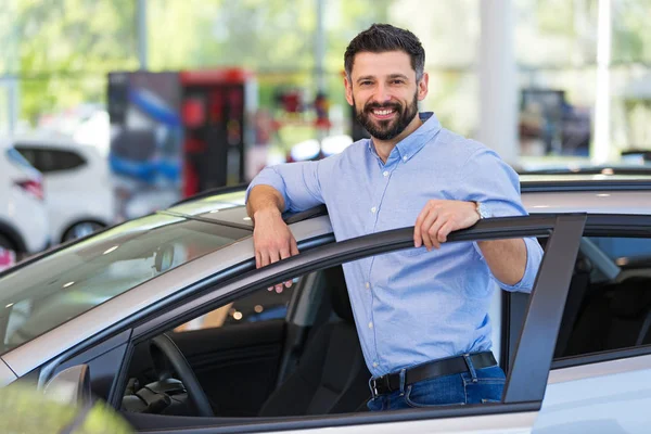 Felice giovane uomo con la sua nuova auto — Foto Stock