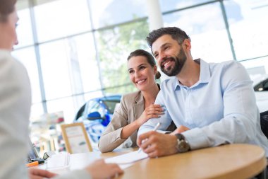 Auto salon araba satıcısı ile genç Çift