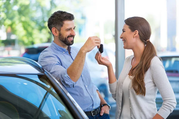 Femme recevant les clés d'un concessionnaire automobile — Photo