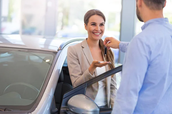 Frau erhält Schlüssel von Autohändler — Stockfoto