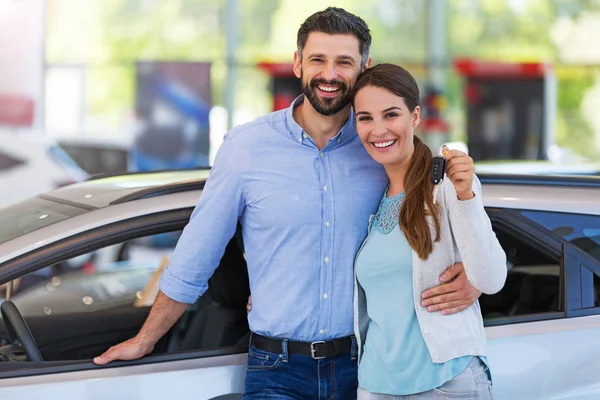 Jeune couple achetant une voiture — Photo