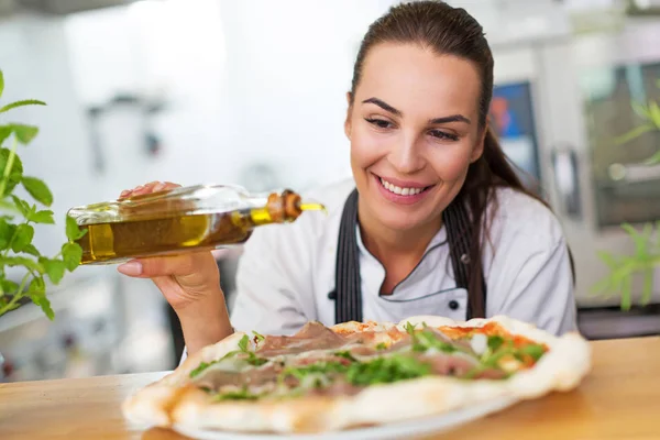 Smiling chef preparing pizza in kitchen — Stock Photo, Image
