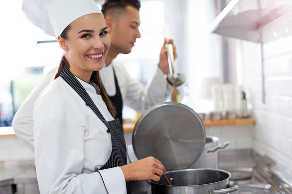 Chef sonriente sosteniendo pizza fresca en la cocina — Foto de Stock