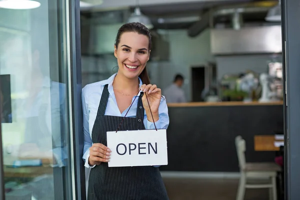 Frau mit offenem Schild in Café — Stockfoto