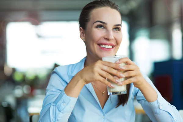 Mulher bebendo latte macchiato no café Fotos De Bancos De Imagens Sem Royalties