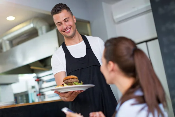 Servitören servering kund på restaurang — Stockfoto