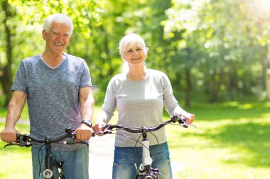 Park 'ta bisiklet süren yaşlı çift.