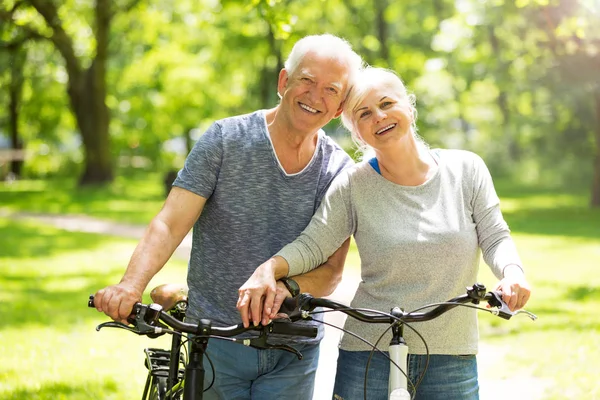 Casal sênior andar de bicicleta no parque — Fotografia de Stock