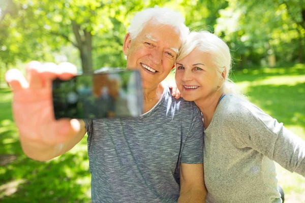 Äldre par med cyklar tar selfie — Stockfoto