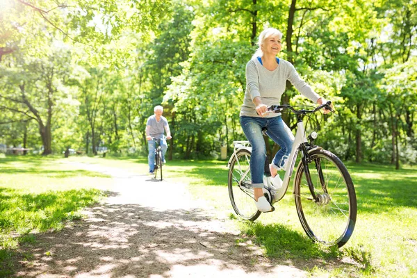 Seniorenpaar fährt Fahrrad im Park — Stockfoto