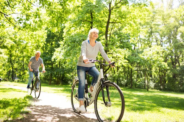 Pareja de ancianos montar bicicletas en el parque — Foto de Stock